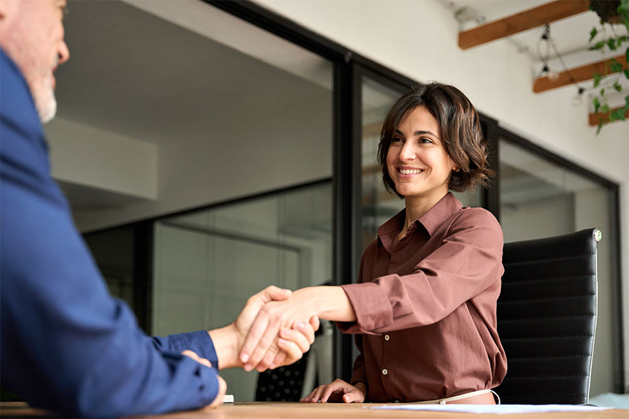 Banker shaking hands with client for personal loan.
